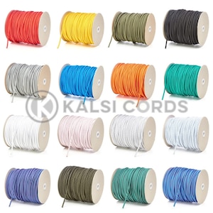May include: Assortment of 12 spools of colourful elastic cord, each wound around a cardboard spool. The cords are in various colours, including red, yellow, green, blue, white, black, and orange.