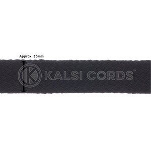 Puede incluir: Primer plano de una cinta negra tejida, de aproximadamente 15 mm de ancho, con el texto "KALSI CORDS" en blanco. La cinta tiene una superficie texturizada y est&aacute; sobre un fondo blanco. La imagen destaca el ancho del producto.