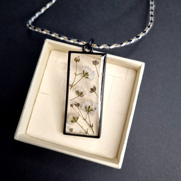 Collier rectangle noir avec fleur de gypsophile naturel dans une résine translucide