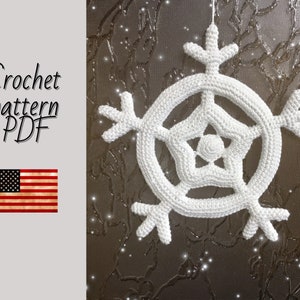 May include: White crochet snowflake ornament with a five-pointed star in the center. The snowflake is hanging from a string against a brown background. Crochet pattern PDF.