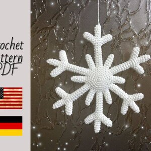 May include: A white crocheted snowflake ornament hanging against a sparkly background. Crochet pattern PDF.