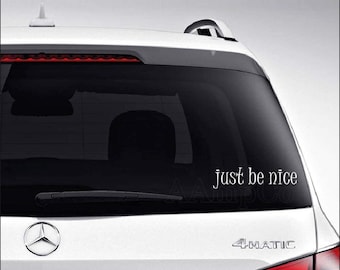May include: White car with a black rear window and a white vinyl decal that reads "Just be nice" on the back window.