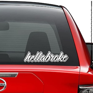 May include: A white vinyl decal with the text "hellabroke" in a stylized font, applied to the rear window of a red car.