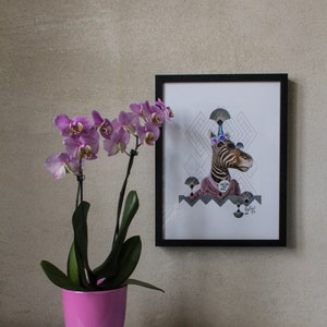May include: A framed print of a zebra wearing a party hat and a pink shirt. The zebra is surrounded by geometric shapes. The print is hanging on a wall next to a pink orchid plant in a pink pot.