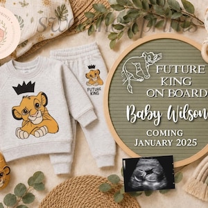May include: A light gray baby sweatshirt and matching joggers featuring a graphic of a lion cub wearing a black crown. The set includes matching lion-themed slippers, a round letter board with the text Future King On Board Baby Wilson Coming January 2025, and a sonogram image.