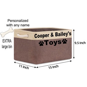 May include: A brown and beige canvas storage bin with a rope handle. The bin is 15 inches wide, 11 inches long, and 9.5 inches tall. It has the text "Cooper & Bailey's Toys" printed on the front with paw prints.