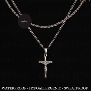 Puede incluir: Dos collares de cadena plateada con un colgante de cruz plateada. Las cadenas son una cadena de cuerda y una cadena de curb. El texto "DI VIOMO" aparece varias veces en la imagen. El texto "WATERPROOF - HYPOALLERGENIC - SWEATPROOF" y "WWW.DIVIOMO.COM" también son visibles.