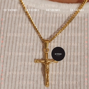 Puede incluir: Un collar de cadena de oro con un colgante de cruz de oro. La cruz presenta una figura de Jesucristo. La cadena es de estilo de cuerda trenzada. El colgante es una cruz simple con un peque&ntilde;o c&iacute;rculo en la parte superior. El c&iacute;rculo tiene el texto "DI VIOMO ITALY" en negro.