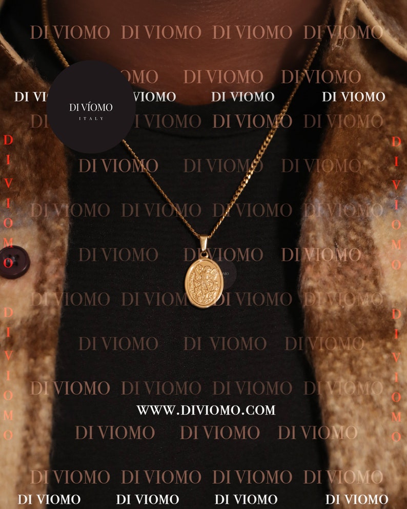 May include: A gold chain necklace with a round pendant featuring a religious image. The necklace is worn by a person wearing a black shirt with the text "DI VIOMO" repeated in a pattern. The text "WWW.DIVIOMO.COM" is also visible on the shirt.