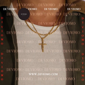 May include: A close-up of a person wearing a white shirt with two gold chains. The chains have a cross pendant. The background is a pattern of the text "DI VIOMO" repeated.