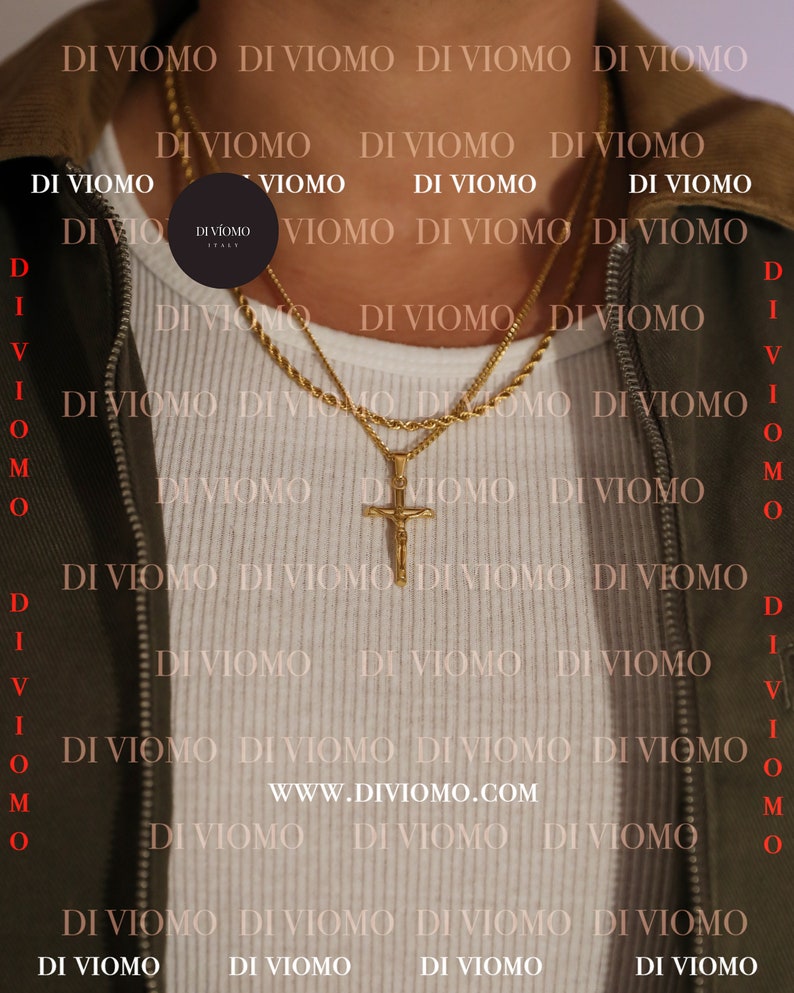 May include: A close-up of a person wearing a white shirt with two gold chains. The chains have a cross pendant. The background is a pattern of the text "DI VIOMO" repeated.