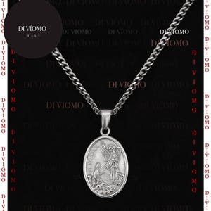 May include: A silver chain necklace with a silver oval pendant featuring a religious image of an angel and a woman. The pendant has the words "St. Raphael" inscribed on it. The necklace is on a black background with the text "DI VIOMO ITALY" in a circle.