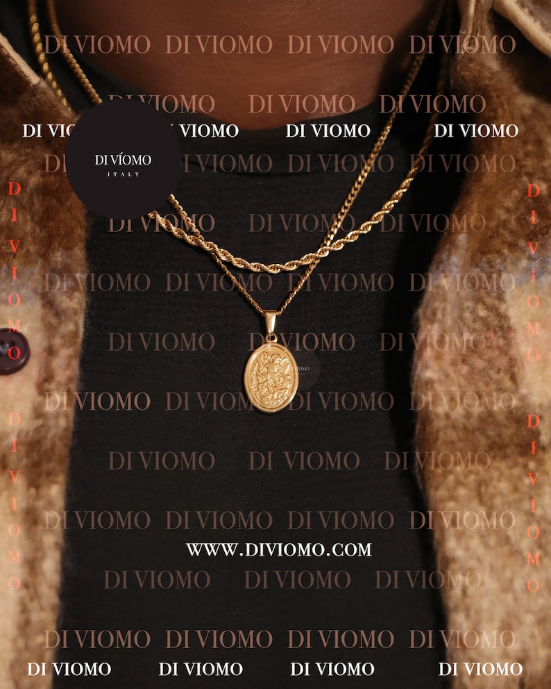 May include: A close-up of a gold chain necklace with a pendant featuring a detailed design. The chain is layered over a black shirt with the text "DI VIOMO" repeated in white.