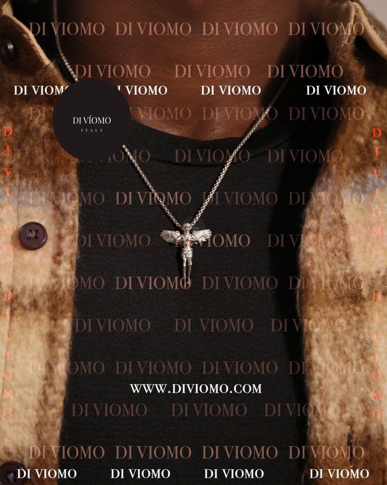 May include: A black t-shirt with the text "DI VIOMO" repeated across the front. A silver chain necklace with a winged angel pendant hangs from the neck. The text "DI V&Iacute;OMO ITALY" is visible on a black circle tag.