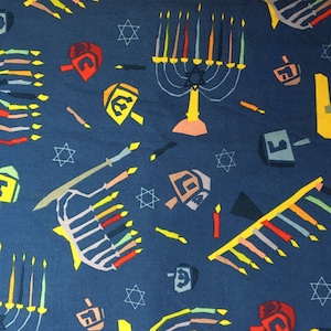 May include: A blue fabric with a repeating pattern of menorahs, dreidels, and stars of David. The menorahs are yellow, orange, and red, and the dreidels are yellow, orange, and red. The stars of David are yellow.
