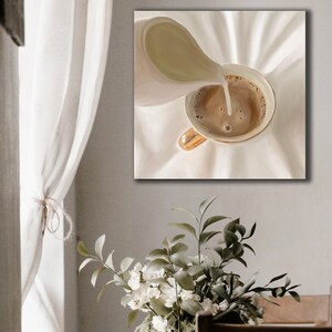 May include: A close-up of a white pitcher pouring cream into a cup of coffee. The cup has a gold rim and is sitting on a white surface.