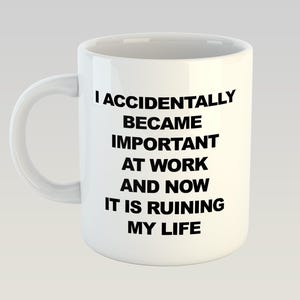 Pode incluir: Caneca de cerâmica branca com uma alça curva. A caneca apresenta o texto preto: "I ACCIDENTALLY BECAME IMPORTANT AT WORK AND NOW IT IS RUINING MY LIFE."