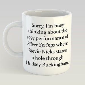 May include: White ceramic mug with a black text quote: "Sorry, I'm busy thinking about the 1997 performance of Silver Springs where Stevie Nicks stares a hole through Lindsey Buckingham."