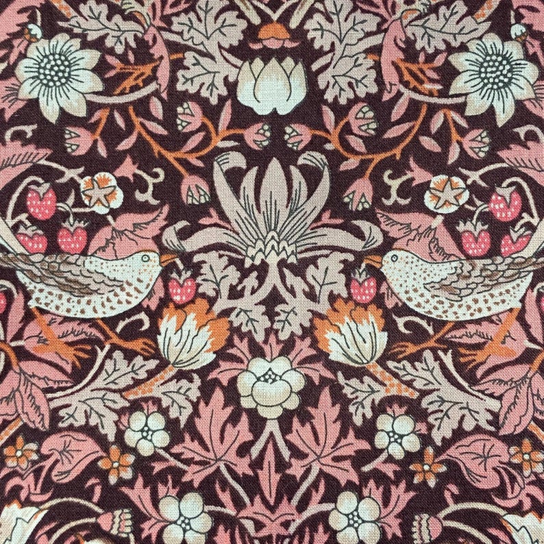 May include: A brown fabric with a repeating pattern of stylized birds, flowers, and leaves. The pattern is in shades of pink, brown, and white.