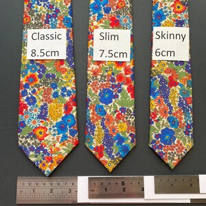May include: Three floral patterned neckties in classic, slim, and skinny styles. The classic tie is 8.5cm wide, the slim tie is 7.5cm wide, and the skinny tie is 6cm wide. The ties feature a colorful floral pattern with red, blue, yellow, and green flowers.