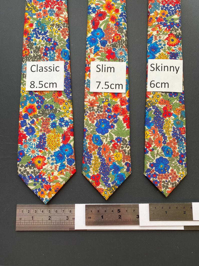 May include: Three floral patterned neckties in classic, slim, and skinny styles. The classic tie is 8.5cm wide, the slim tie is 7.5cm wide, and the skinny tie is 6cm wide. The ties feature a colorful floral pattern with red, blue, yellow, and green flowers.