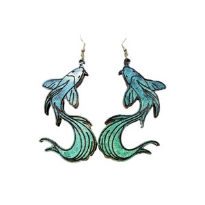 May include: A pair of blue and green fish-shaped earrings with silver hooks. The fish are facing each other and their tails are flowing in the water.