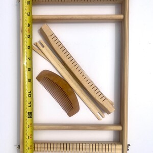 Pode incluir: Um kit de tear de madeira com uma fita m&eacute;trica. O kit inclui uma estrutura retangular, um pente, duas lan&ccedil;adeiras e uma agulha de tecelagem. A estrutura mede aproximadamente 43 cm de altura.