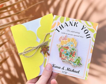 May include: A yellow scalloped-edge card tied with twine and a wooden palm tree charm, next to a thank you card. The thank you card has a colorful Oahu, Hawaii pin and text that reads "Thank You" and "Kara & Michael 1.7.27".