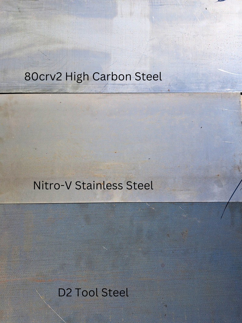 May include: Three metal samples labelled with their steel types: 80crv2 High Carbon Steel, Nitro-V Stainless Steel, and D2 Tool Steel.