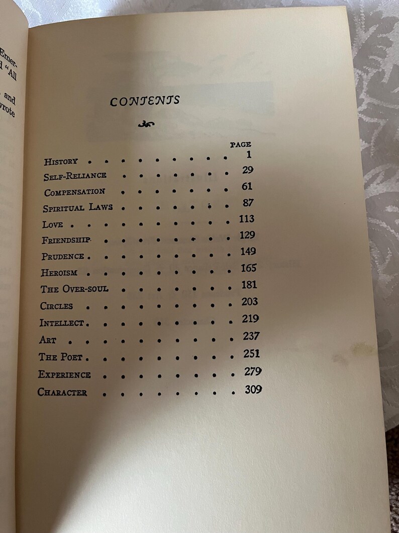 May include: A black and white book with the title "CONTENTS" and a list of chapters with page numbers. The chapters include "History", "Self-Reliance", "Compensation", "Spiritual Laws", "Love", "Friendship", "Prudence", "Heroism", "The Over-Soul", "Circles", "Intellect", "Art", "The Poet", "Experience", and "Character".