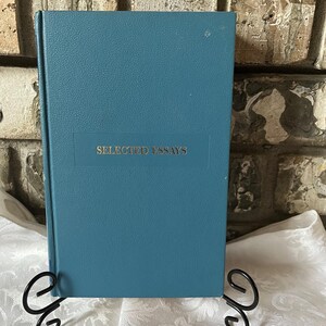 May include: A teal blue hardcover book with the title "SELECTED ESSAYS" printed in silver on the front cover.