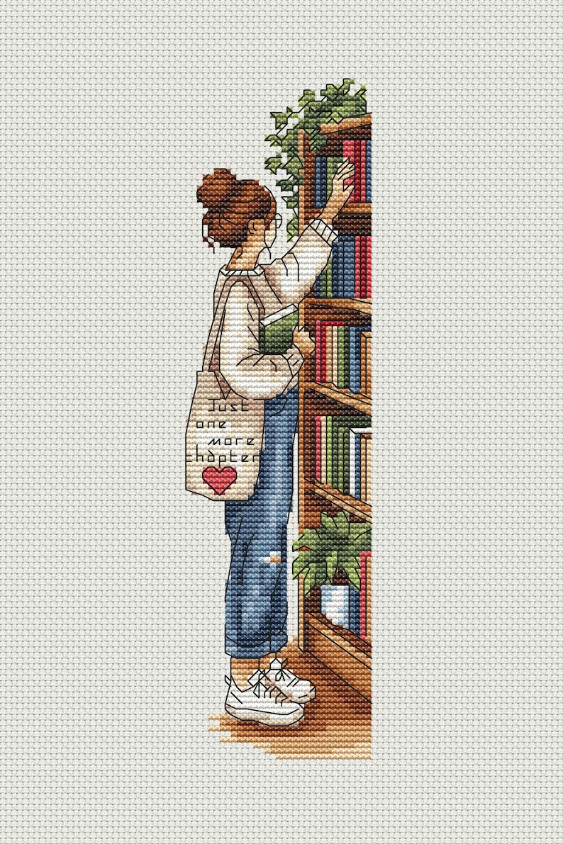 Op de afbeelding: Kruissteek illustratie van een persoon die een boek uit een houten boekenkast kiest. De persoon draagt een wit overhemd, een blauwe spijkerbroek en witte sneakers. Een draagtas met de tekst "Just one more chapter" en een hart is zichtbaar.