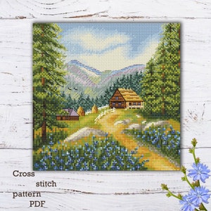 Op de afbeelding: Cross stitch patroon PDF van een kleurrijk landschap met een klein huis, bomen en een kronkelend pad dat naar het huis leidt. De achtergrond toont een bergketen en een blauwe lucht met witte wolken.