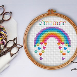 Può includere: Schema a punto croce PDF per un arcobaleno con cuori. L'arcobaleno è in tonalità di viola, blu, verde, giallo, arancione e rosso. La parola "Summer" è ricamata sopra l'arcobaleno.