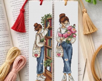 Könnte beinhalten: Zwei rechteckige Lesezeichen mit Kreuzstichmotiven einer Person mit Dutt. Eines zeigt die Person, wie sie nach einem Bücherregal greift, das andere hält ein Buch und rosa Blumen. Beide tragen eine Tasche mit dem Text Just one more chapter.