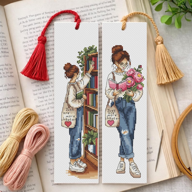 Op de afbeelding: Twee kruissteek bladwijzers met illustraties van een persoon met een knot, bril en jeans. E&eacute;n reikt naar een boek, de ander houdt een boek en bloemen vast. Elke heeft een tas met de tekst "Just one more chapter".