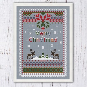 May include: Cross stitch pattern featuring a winter scene with reindeer, snowflakes, and the text "Merry Christmas". The pattern is framed in a white frame and has a grey background.