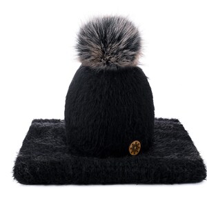 Peut inclure: Chapeau noir en tricot fuzzy avec un pompon en fausse fourrure noire et un bouton en forme de flocon de neige brun. Le chapeau est assorti à une écharpe noire fuzzy.