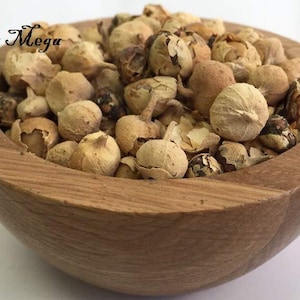 Peut inclure: Un bol en bois rempli de gousses d'épices séchées de couleur beige. Le bol est en bois brun clair et repose sur une surface blanche. Le texte "Organic Mega Mart" est écrit en haut à gauche de l'image.