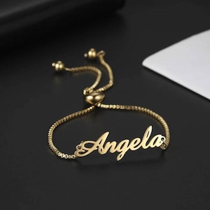 May include: A gold adjustable bracelet with the name "Angela" in a cursive font.
