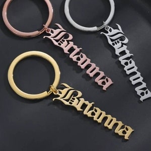 May include: Three gold, silver, and rose gold keychains with the name "Brianna" in a gothic font.