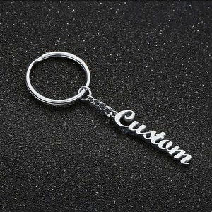 May include: Silver keychain with a silver ring and a silver charm that says "Custom".