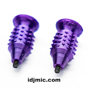 May include: Two purple metal spikes with a textured, studded surface and a flat, circular top. Each spike features a small, threaded black metal screw protruding from the pointed base. The text idjmic.com is printed in black at the bottom.