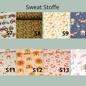 May include: A collection of eight fabric swatches labeled S7 through S14, featuring various patterns including tractors, construction vehicles, dinosaurs, forest animals, lions, foxes, and sea creatures, all displayed under the text Sweat Stoffe.