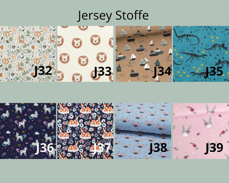 May include: A collection of eight jersey fabric swatches labeled J32 through J39, featuring patterns of giraffes, lions, boats, dinosaurs, unicorns, deer, crabs, and rabbits in various colors including blue, pink, brown, and cream.