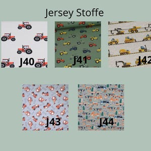 May include: Five swatches of jersey fabric labeled J40 through J44. J40 features red tractors on white. J41 shows tractors on olive green. J42 displays yellow construction vehicles on light gray. J43 has helicopters on blue. J44 shows cars on gray.