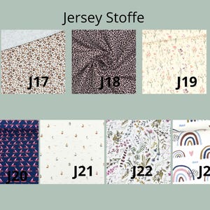 K&ouml;nnte beinhalten: Eine Sammlung von sieben Jersey-Stoffmustern, beschriftet von J17 bis J23. Die Muster umfassen braunen Leopardenprint, schwarzen Leopardenprint, kleine Blumen, marineblau mit rosa Segelbooten, wei&szlig;e Segelboote, botanische Wildblumen und Regenbogenmotive.