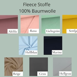 K&ouml;nnte beinhalten: Eine Sammlung von Fleece-Stoffmustern mit der Aufschrift Fleece Stoffe 100% Baumwolle, in den Farben Altlila, Rosa, Lichtgr&uuml;n, Senfgelb, Hellblau, Marine, Beige, Grau und Hellgrau, jeweils mit den entsprechenden Textbeschriftungen.