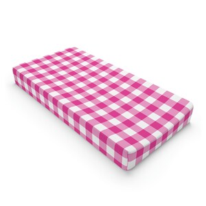 Könnte beinhalten: Rosa-weiß kariertes Babybettlaken. Das Laken ist aus weichem, atmungsaktivem Stoff und perfekt für ein Babyzimmer.