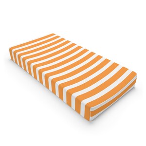 May include: Orange and white striped fitted crib sheet.